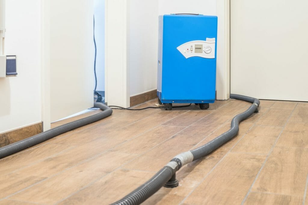 Blauer Bautrockner zur Estrichtrocknung nach Wasserschaden