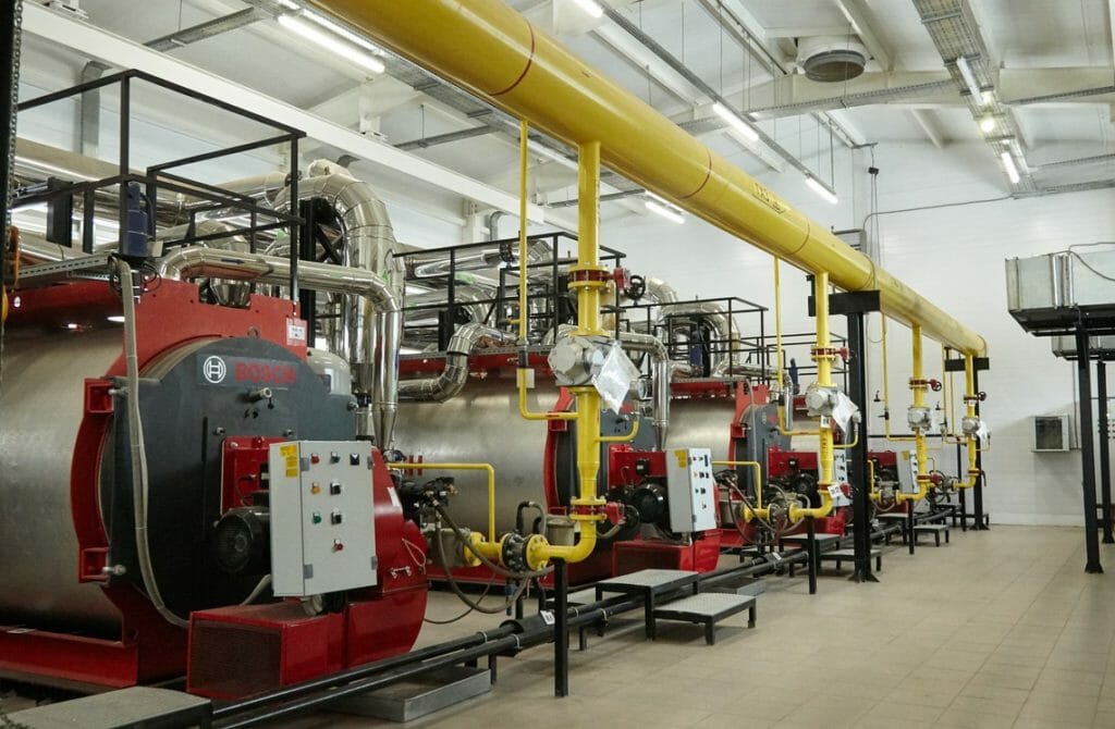 Mehrere Dampfkessel in einer Produktionshalle
