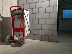 Weißes mobiles Heizgerät montiert auf Sackkarre auf Baustelle