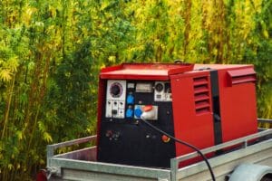 Roter mobiler Stromerzeuger auf einem Anhaenger produziert Strom für mobile Heizzentrale