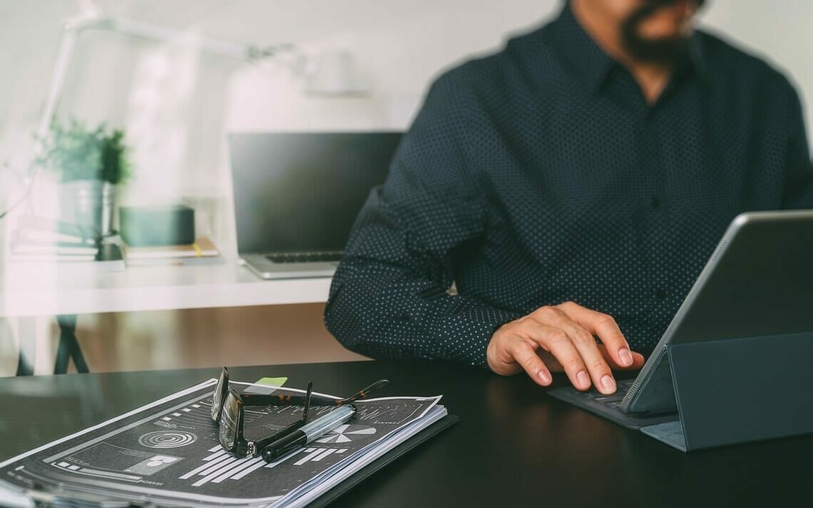 Ingenieur macht eine Kuehllastberechnung mit einem Laptop am Schreibtisch im Buero