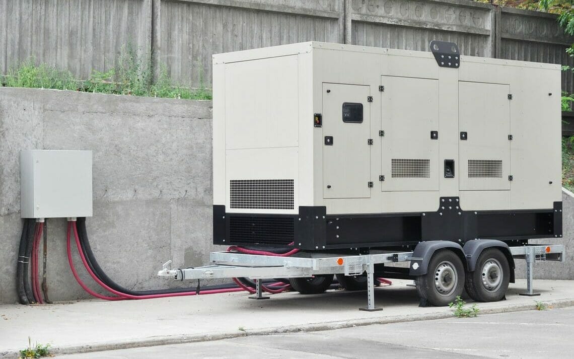 Starkstromgenerator, weißes Starkstromaggregat vor Baustelle