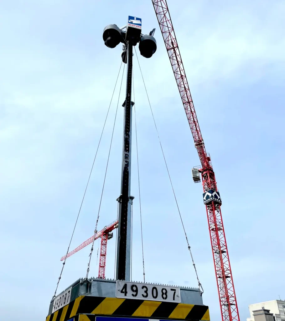 Baustellenueberwachung mit Videoturm und Kran im Hintergrund