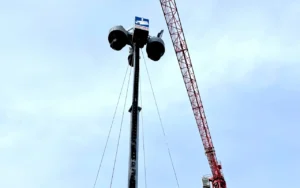 Baustellenueberwachung mit Videoturm und Kran im Hintergrund