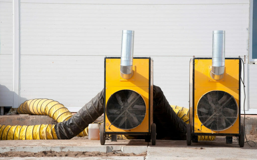 Warmlufterzeuger führen warme Luft über Warmluftschläuche in das Gebäude