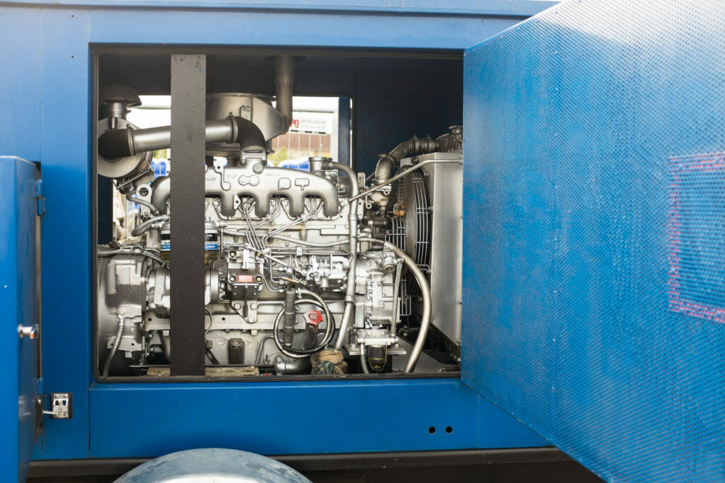 gemietetes blaues BHKW mit geöffneter Seitenklappe und freiem Blick auf den Motor