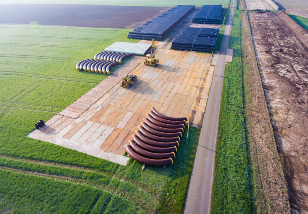 Mobile Baustrasse mit Stahlplatten auf einem Feld verlegt um eine Erdgaspipeline zu bauen