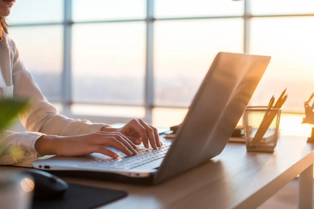 Ein Interessent sitzt vor seinem Laptop am Schreibtisch und sucht im Internet nach Dienstleistungen